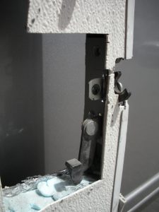 Latch mechanism viewed from inside of door.  Lever in lower right is what releases the spring-loaded latch.